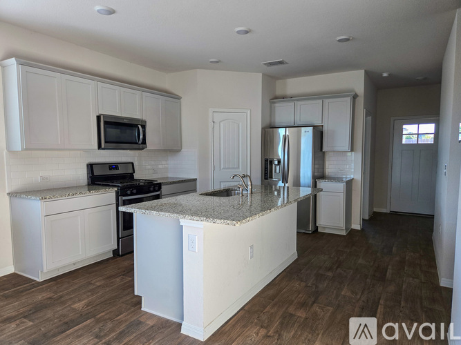 A kitchen with white cabinets and a granite countertop.