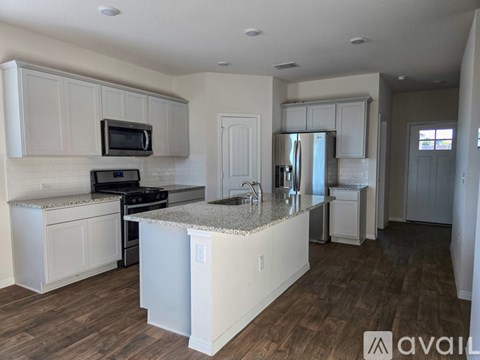 A kitchen with white cabinets and a granite countertop.
