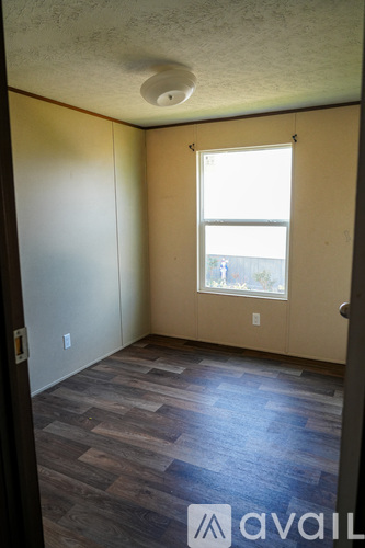 A room with wooden flooring and a window.