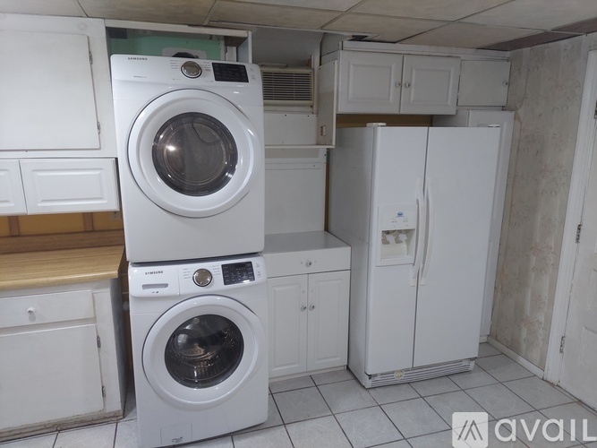 A white washing machine and fridge in a kitchen.