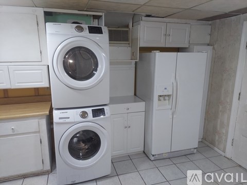 A white washing machine and fridge in a kitchen.