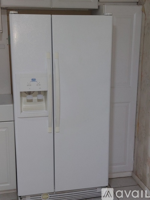 A white fridge with a water and ice dispenser in the middle.