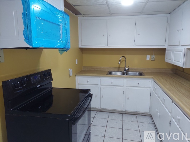 A kitchen with black appliances and white cabinets.