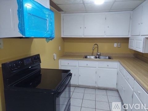 A kitchen with black appliances and white cabinets.