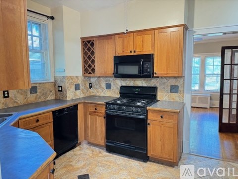 A kitchen with wooden cabinets and black appliances.