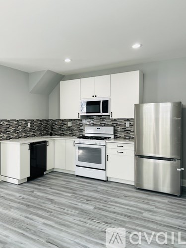A modern kitchen with white cabinets and stainless steel appliances.