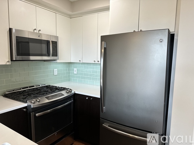 A kitchen with a wooden floor and white walls.