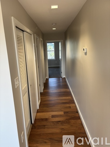 A room with a large window and wooden flooring.