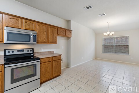 A kitchen with wooden cabinets and a stove top oven.