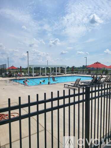 A black fence surrounds a pool with people in it.