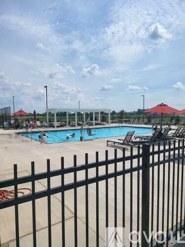 A black fence surrounds a pool with people in it.