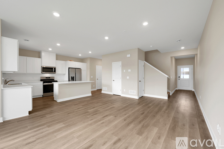 A spacious garage with a closed white door and a hanging light fixture.