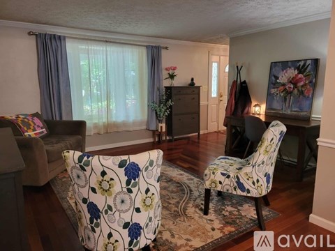 A living room with a floral patterned chair in the foreground.