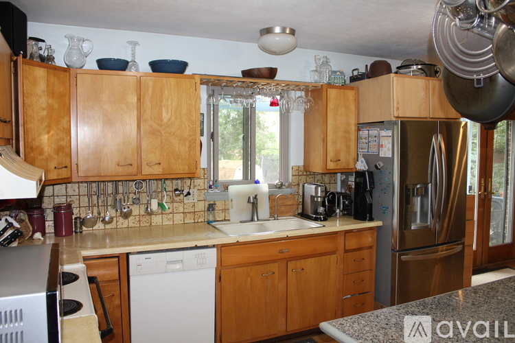 A kitchen with wooden cabinets and a stainless steel refrigerator.