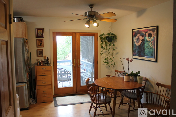A dining room with a wooden table and chairs.