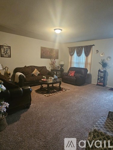 A living room with a black couch and a coffee table.