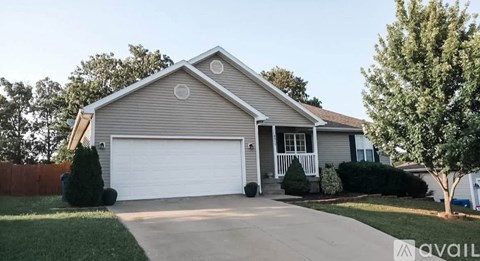 A house with a garage and a driveway is available for sale.