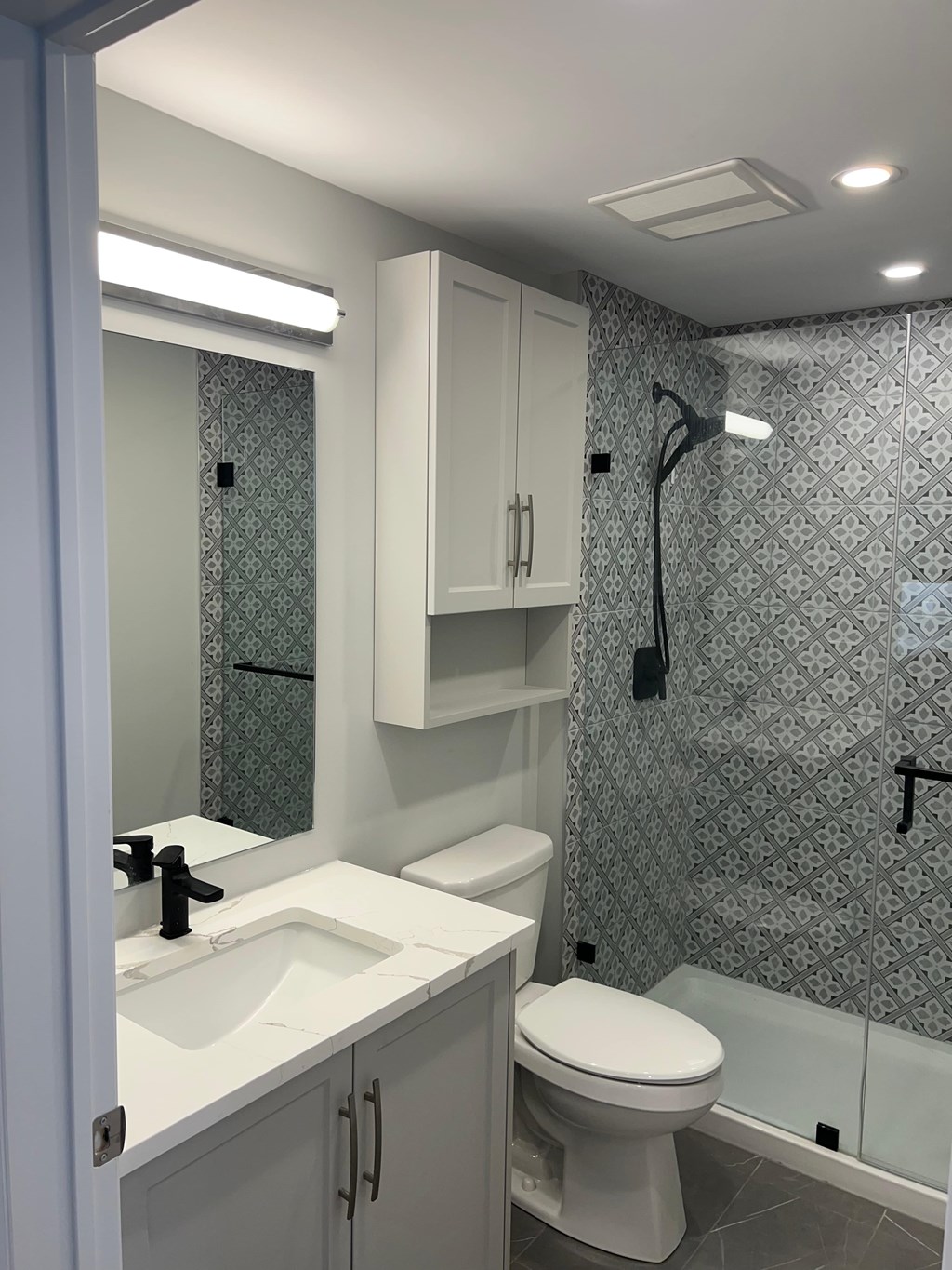 A bathroom with a toilet, sink, and shower.