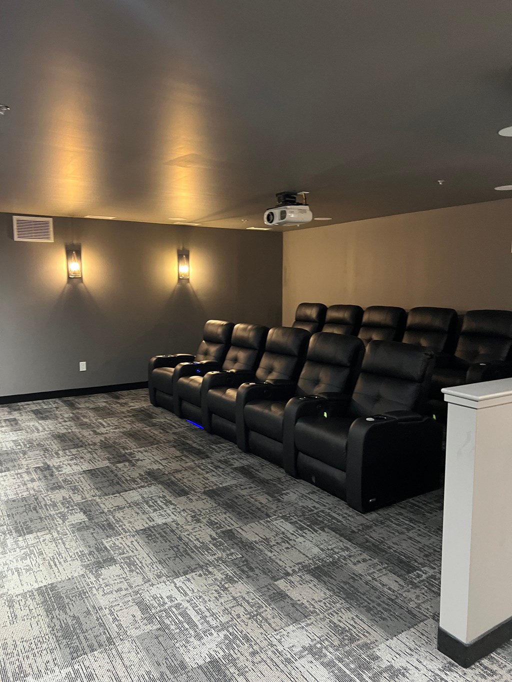 A row of black leather seats in a movie theater.