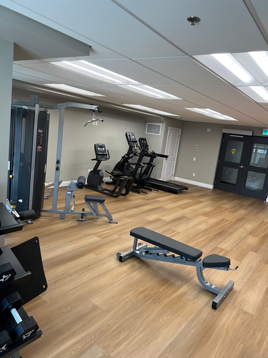 A gym with a variety of equipment including weights and machines.