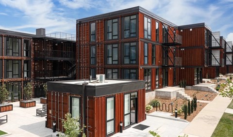 A modern building with a black and brown exterior and glass windows.