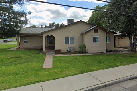 A house with a brown roof and a small front yard.