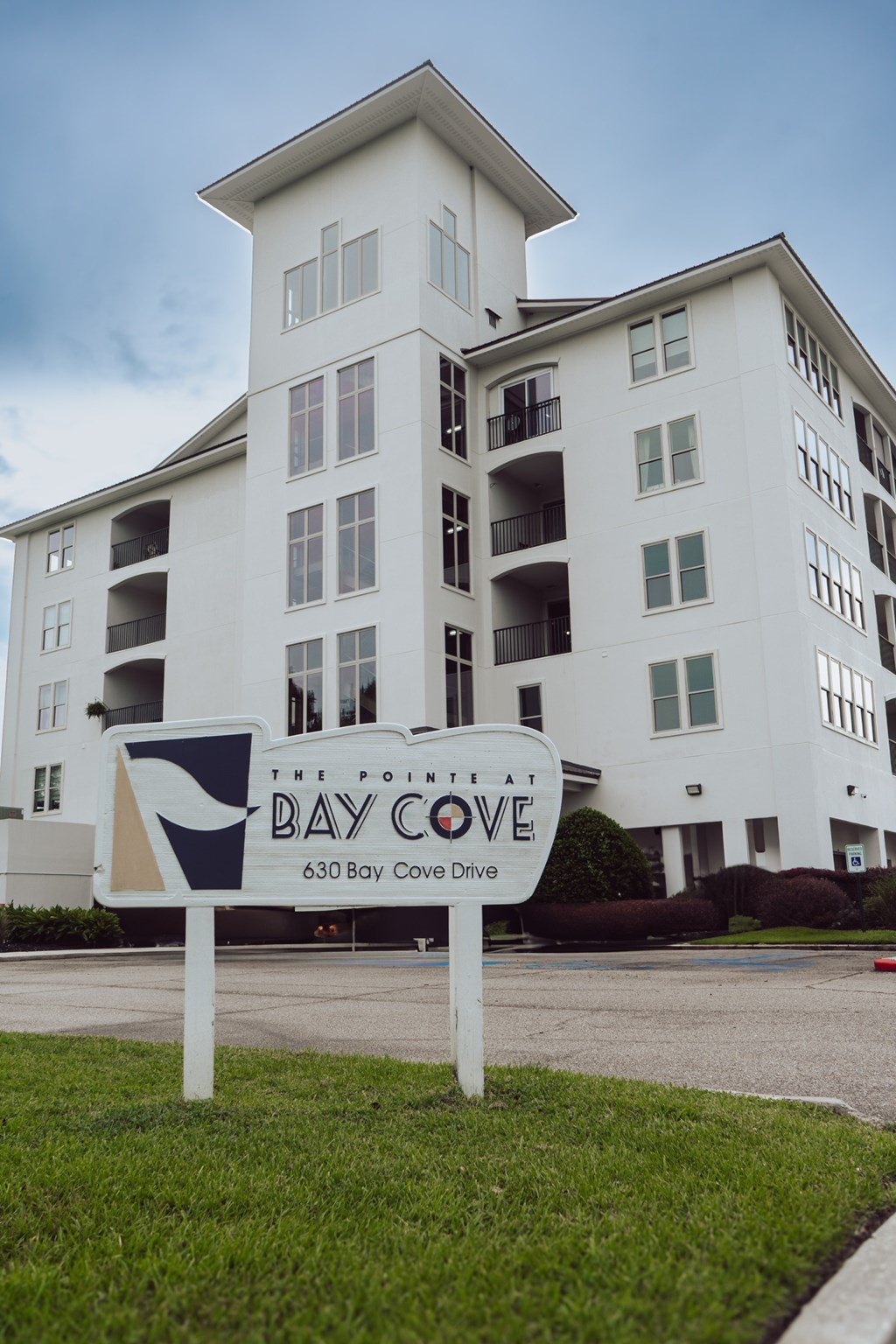 A white building with a sign that says Bay Cove in front of it.