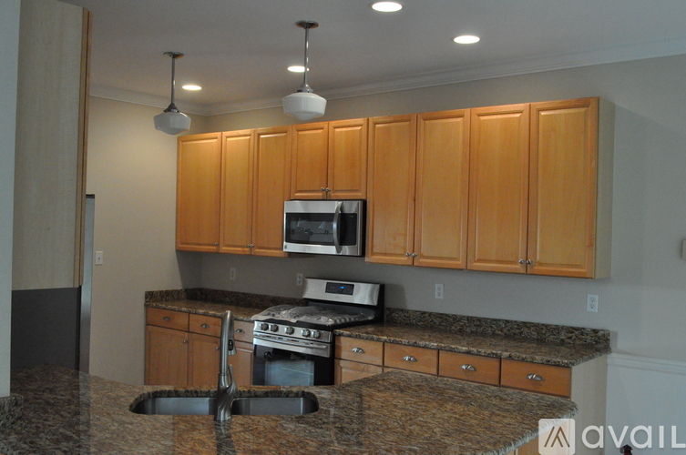 A kitchen with wooden cabinets and a granite countertop.