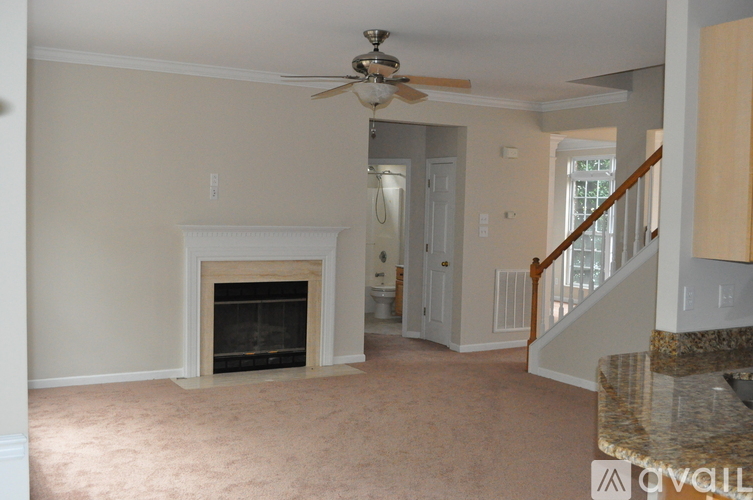 A living room with a fireplace and a ceiling fan.