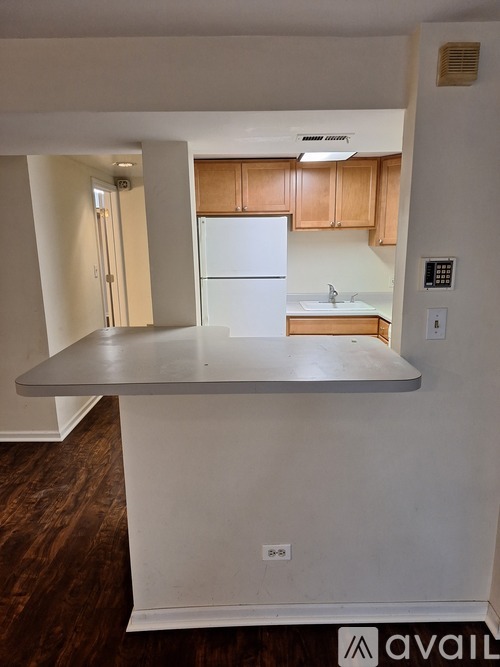 A kitchen with a white fridge and wooden cabinets.