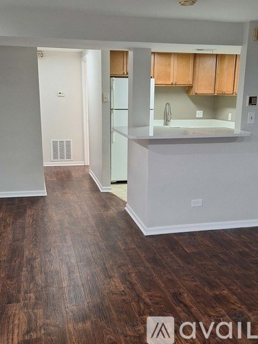 A kitchen with a white fridge and wooden cabinets.