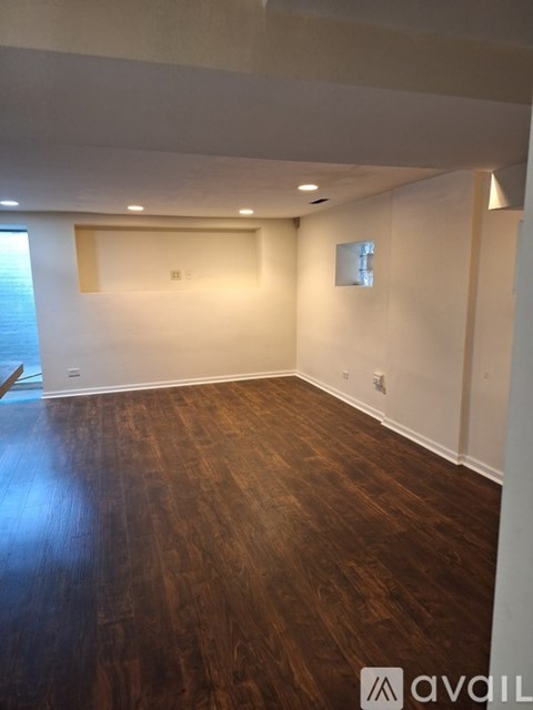 A room with wooden flooring and white walls.