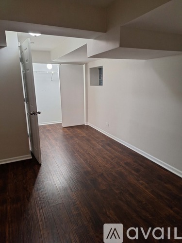 A room with a wooden floor and a white door.