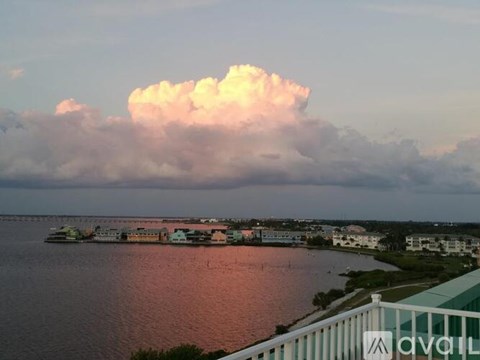 A large cloud is in the sky over a body of water.