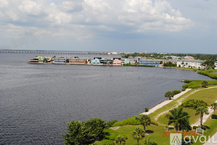 A large body of water with a dock and buildings in the distance.