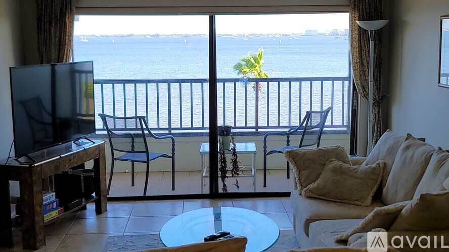 A living room with a balcony overlooking the water.