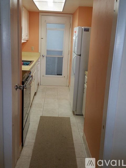 A kitchen with a refrigerator and a door.