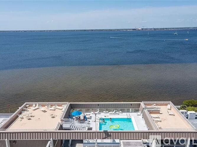 A hotel balcony with a pool and beach in the background.
