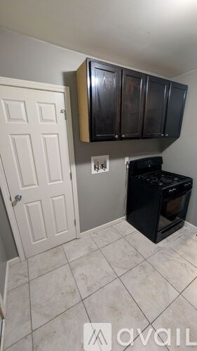 A kitchen with a black oven and white cabinets.