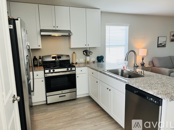 A kitchen with white cabinets and a granite countertop.
