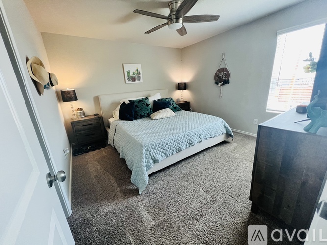 A bedroom with a bed, nightstand, and a ceiling fan.
