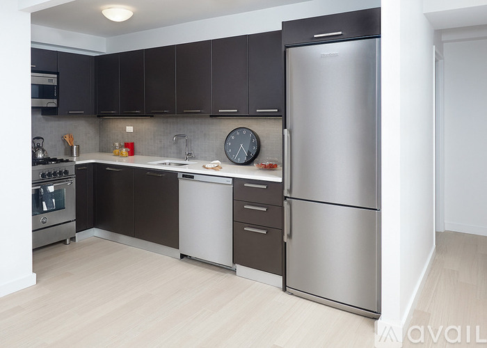A modern kitchen with dark brown cabinets and stainless steel appliances.