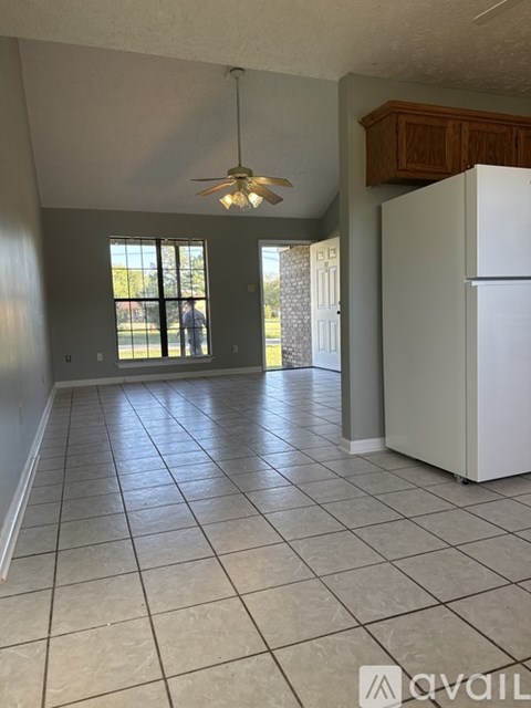 A kitchen with a white refrigerator and a ceiling fan.