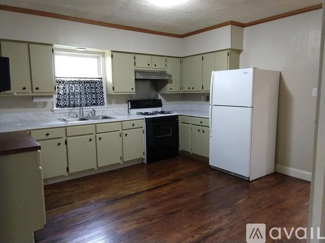A kitchen with wooden floors and white appliances.