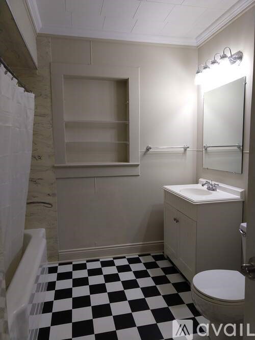 A bathroom with a checkered floor and a white toilet.