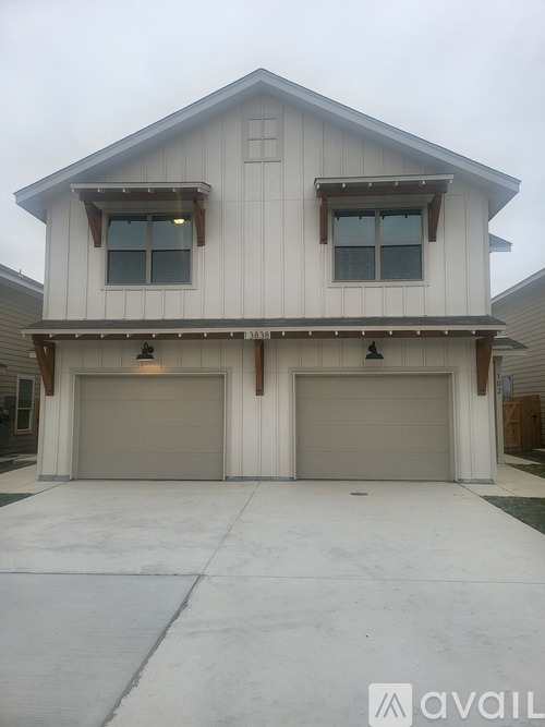 A two-car garage with a white exterior and a brown trim.