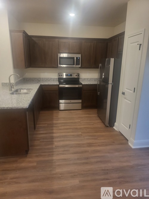 A kitchen with wooden cabinets and a stainless steel refrigerator.