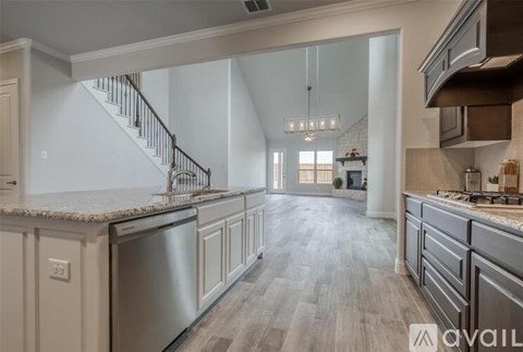 A modern kitchen with a stainless steel dishwasher and a wooden floor.