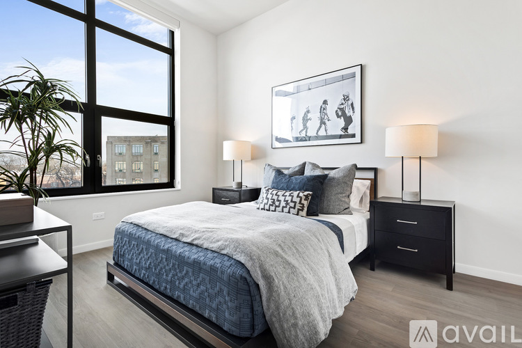 A bedroom with a large bed and a framed picture on the wall.