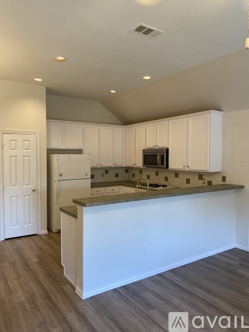 A kitchen with white cabinets and a countertop.